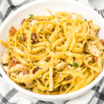 close up of a large white bowl of chicken carbonara