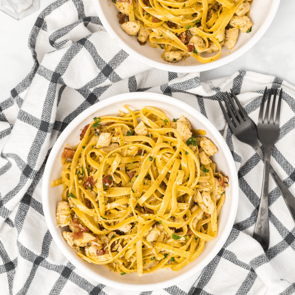 two white bowls of chicken bacon carbonara