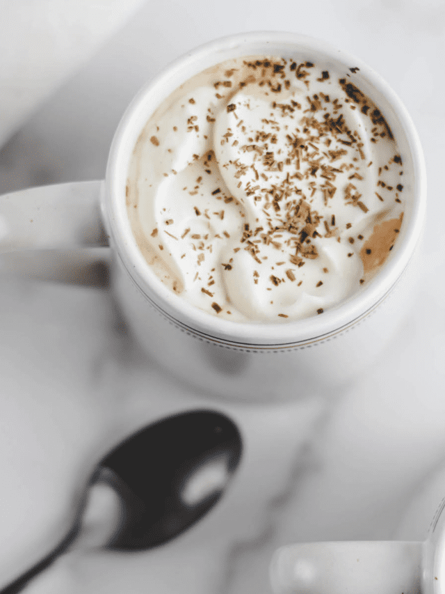 homemade latte in a white mug with whipped cream on top