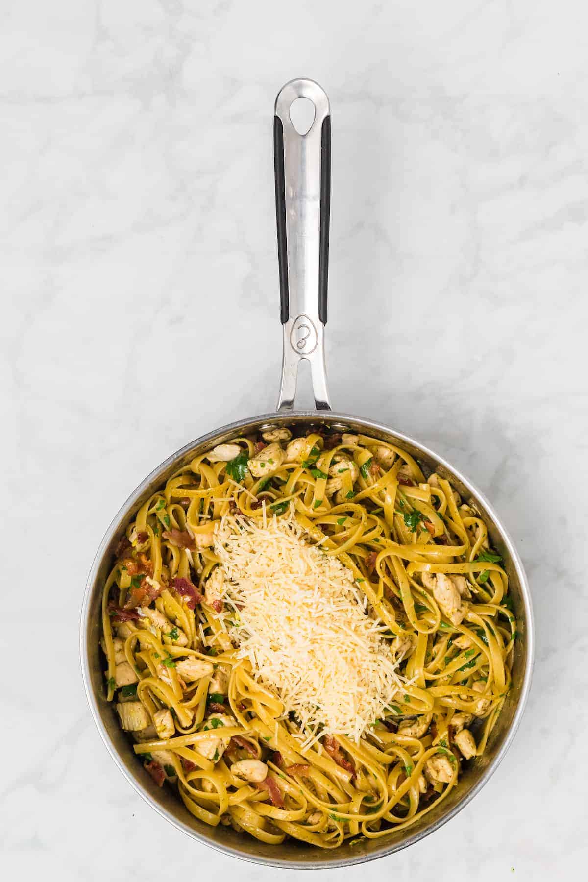 fresh shredded parmesan cheese added to the top of the cooked pasta carbonara