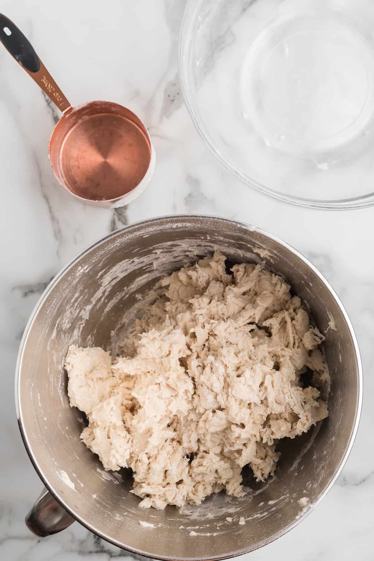 shaggy dough ball inside of the stand mixer bowl.