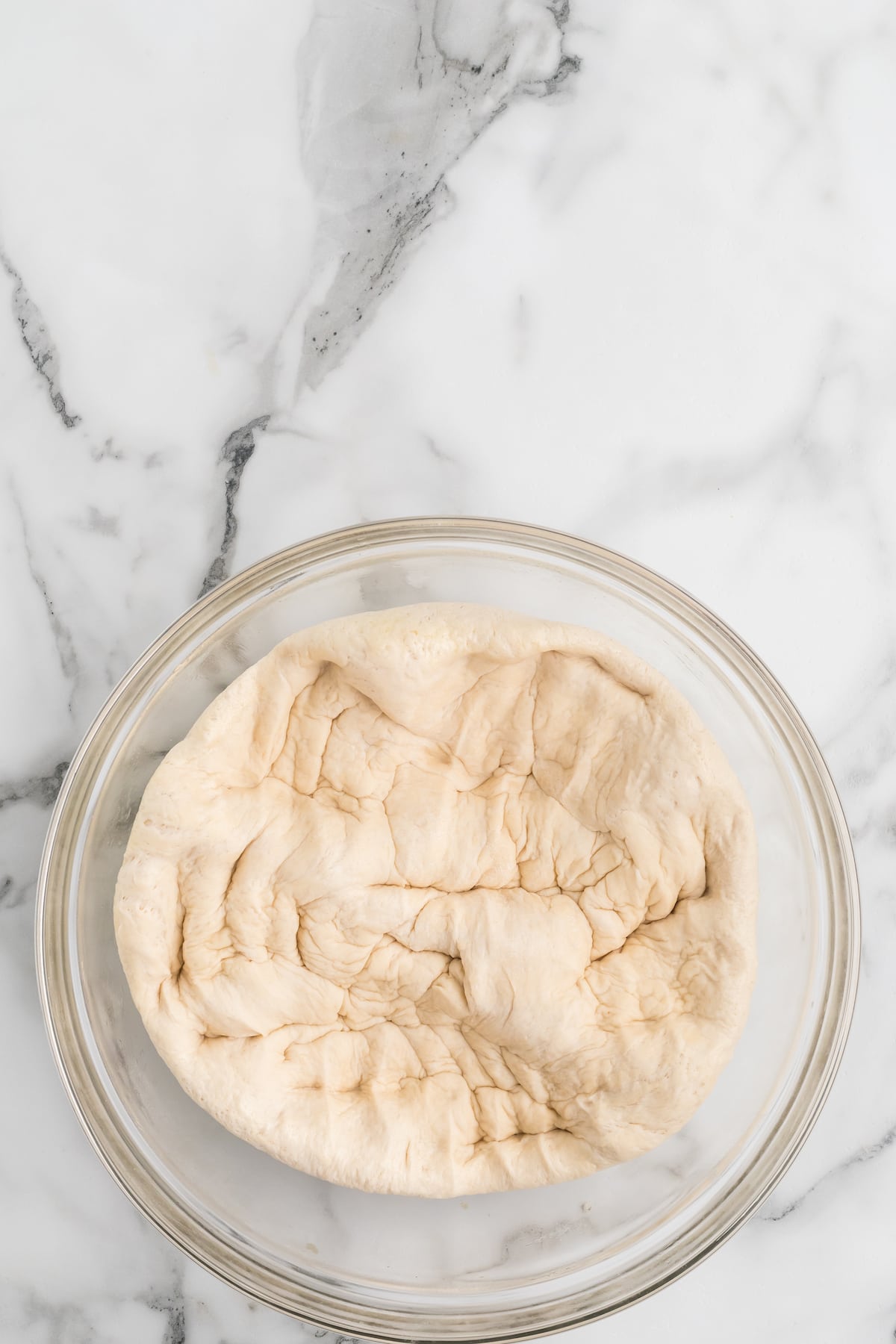 punched down dough inside of the glass bowl. 