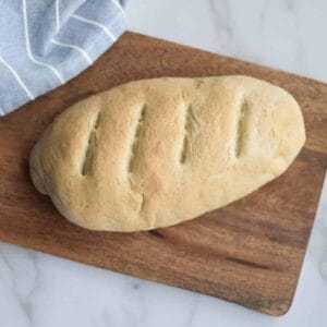 fresh baked italian bread loaf on a wooden cutting board