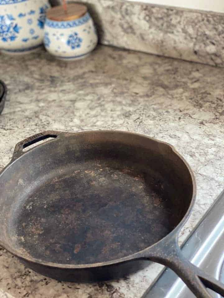 rusty cast iron skillet on a kitchen counter