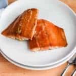 two finished Traeger grilled salmon pieces on a white plate