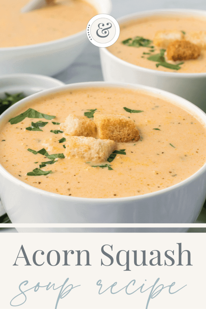 white bowls of creamy acorn squash soup recipe topped with herbs and croutons