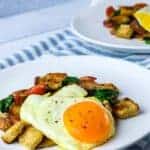 Mediterranean breakfast on two white plates with blue and white striped tea towel