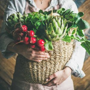 lady carrying basket of fresh harvested vegetables