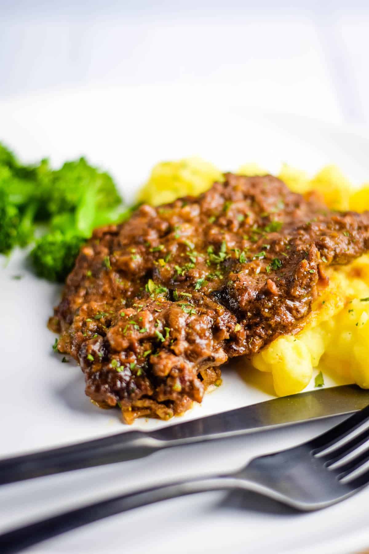 minute steak on a white plate with mashed potatoes