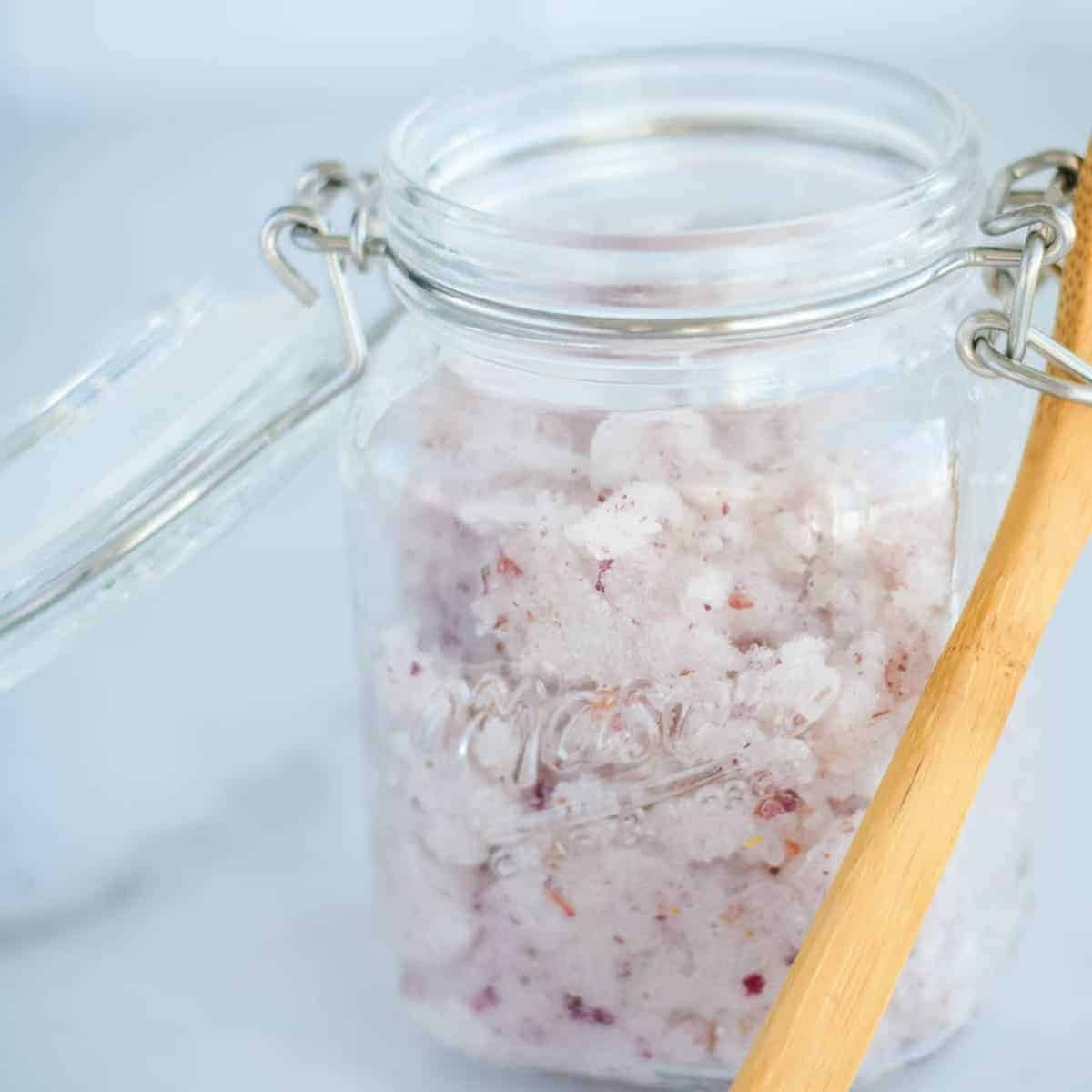 diy rose sugar scrub in a mason jar with a small wooden spoon