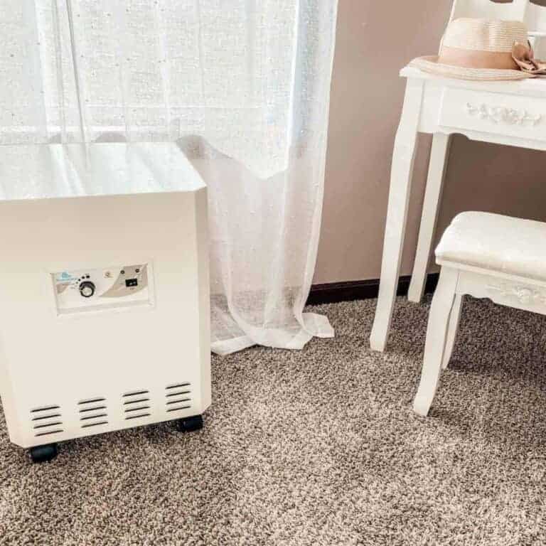 EnviroKlenz Air Purifier in bedroom with sheer white curtains in background