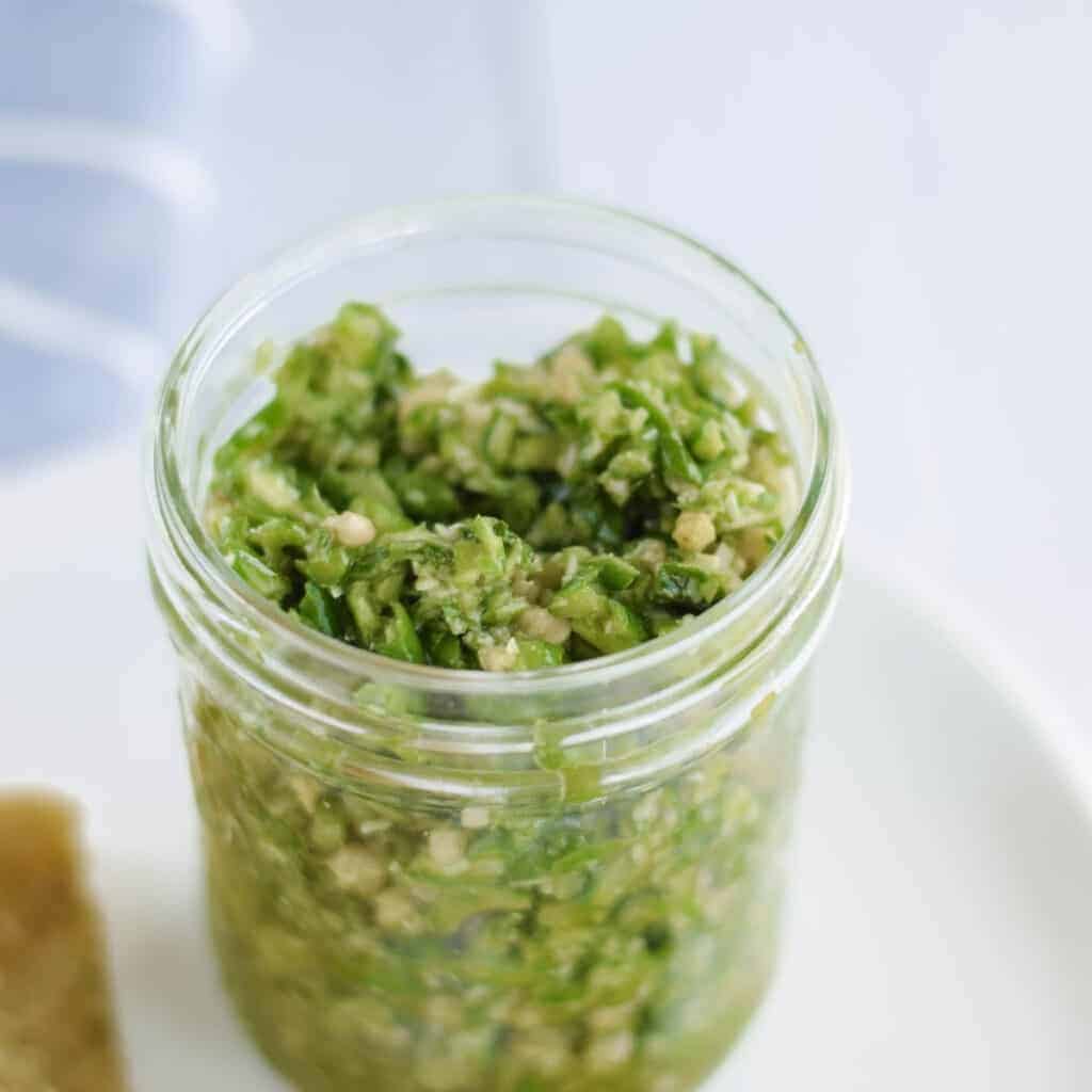 close up image of garlic pesto in a mason jar