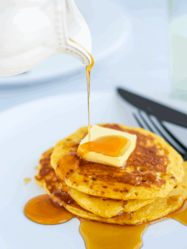 pouring real maple syrup over a stack of cooked einkorn sourdough pancakes