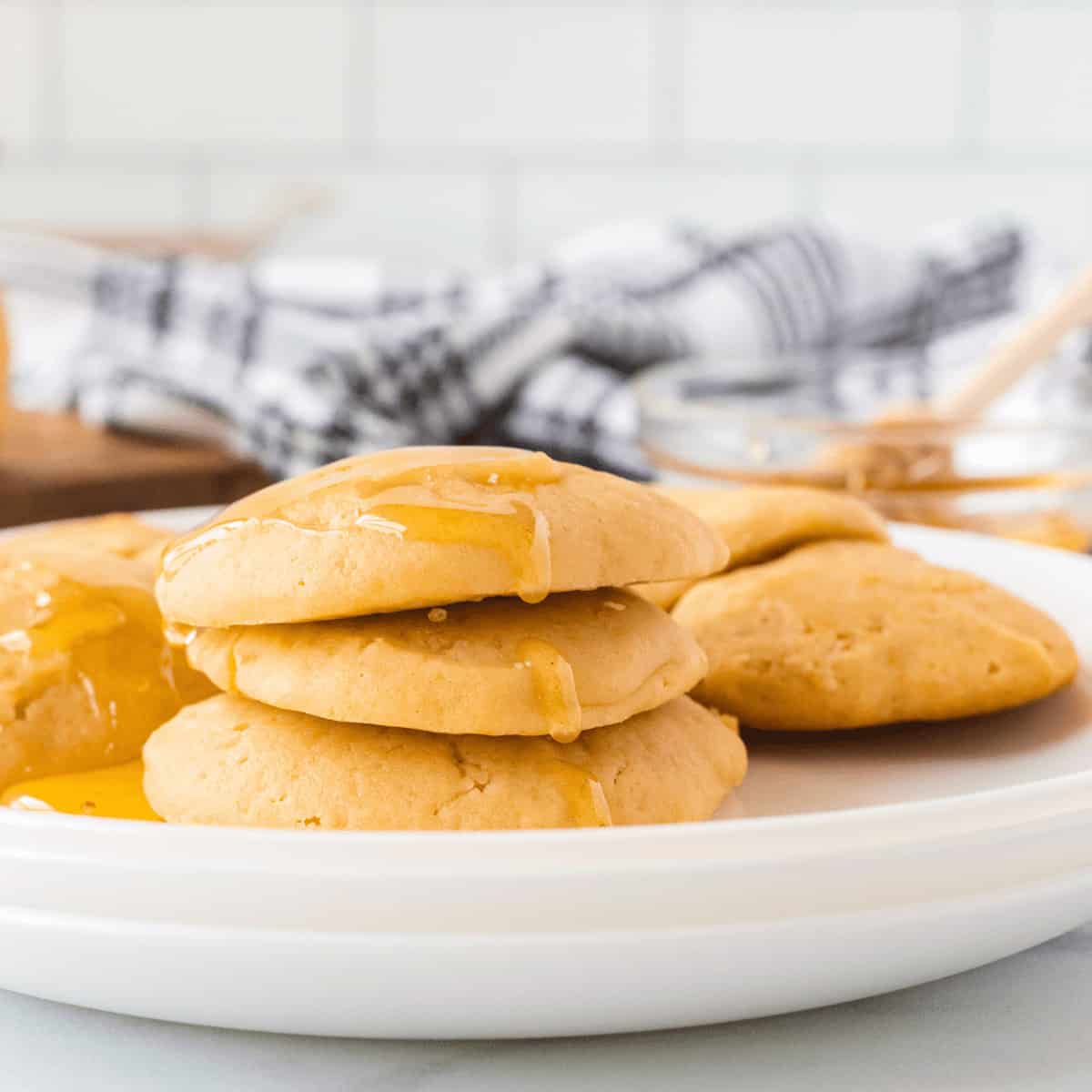 honey butter cookies on a white tray with honey in background