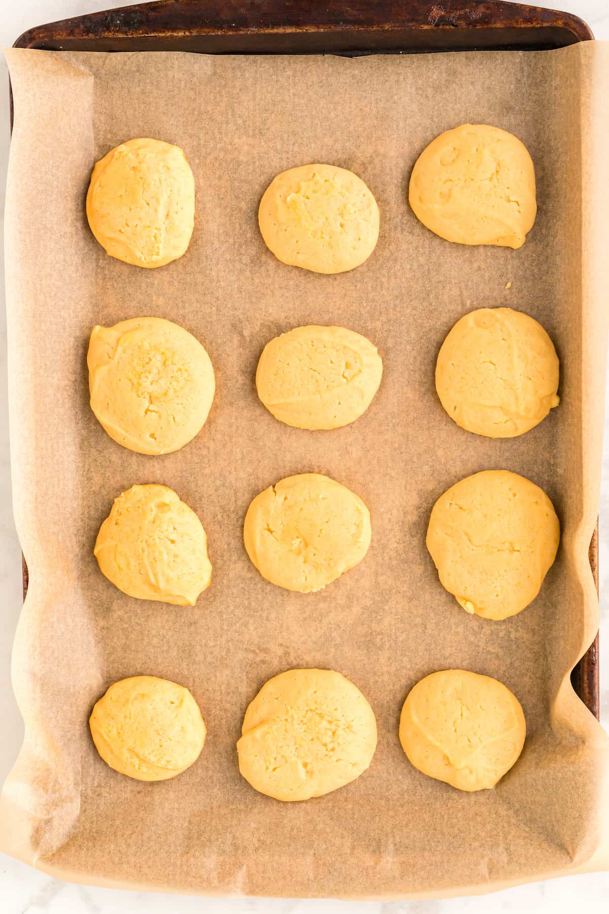 cookies on a baking sheet and parchment paper out of the oven