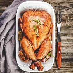 roast chicken in a white roast pan 