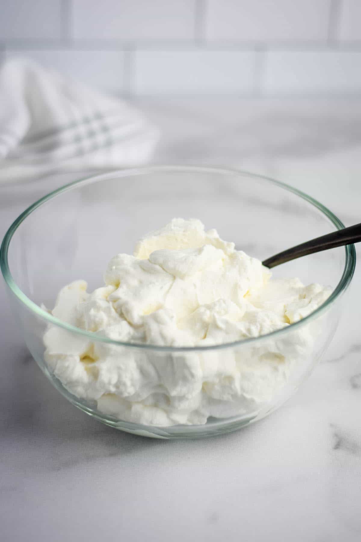 clear glass bowl filled with finished maple whipped cream