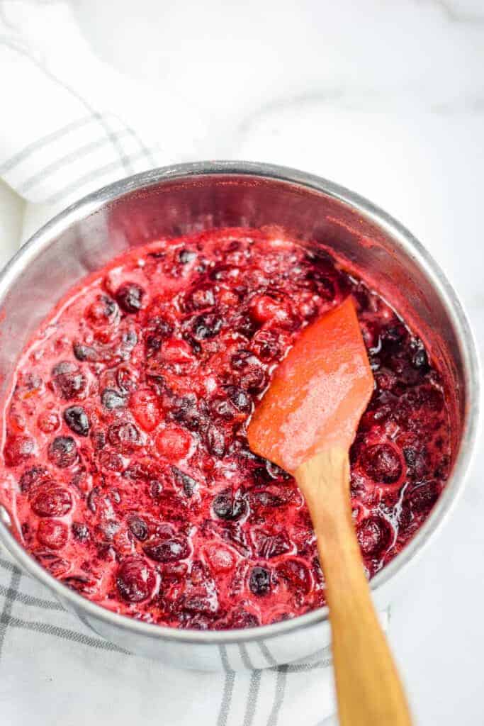 cooked cranberry sauce in a sauce pan with a spatula