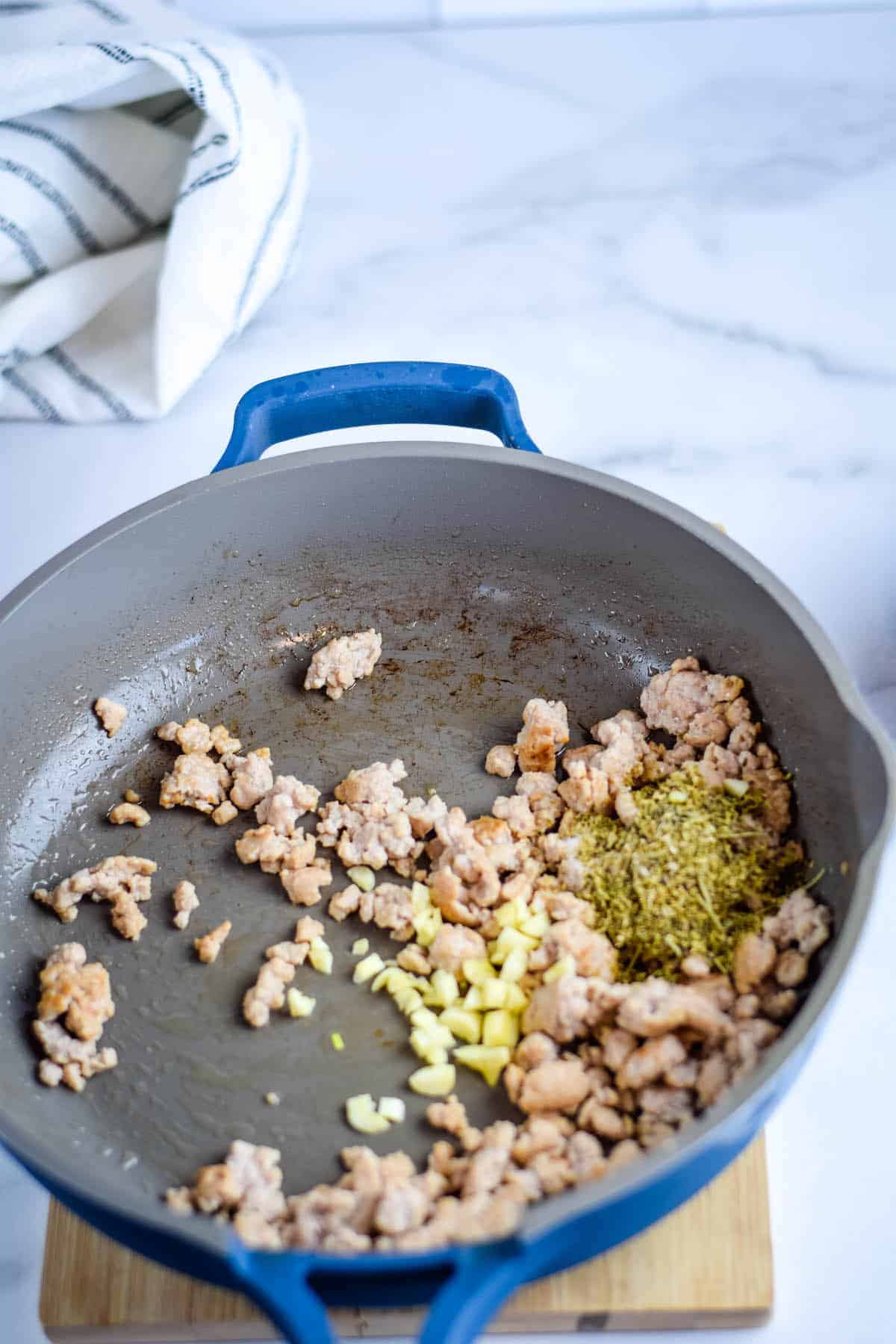 sausage and garlic in a saute pan with italian seasoning