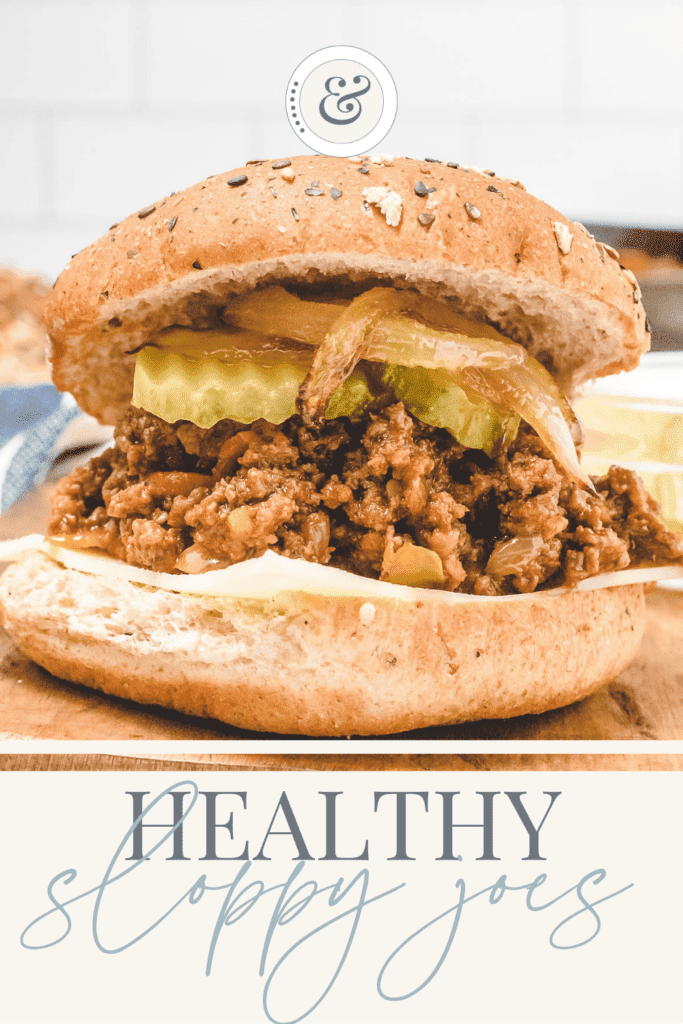 a wooden cutting board with healthy sloppy joes on whole wheat bun