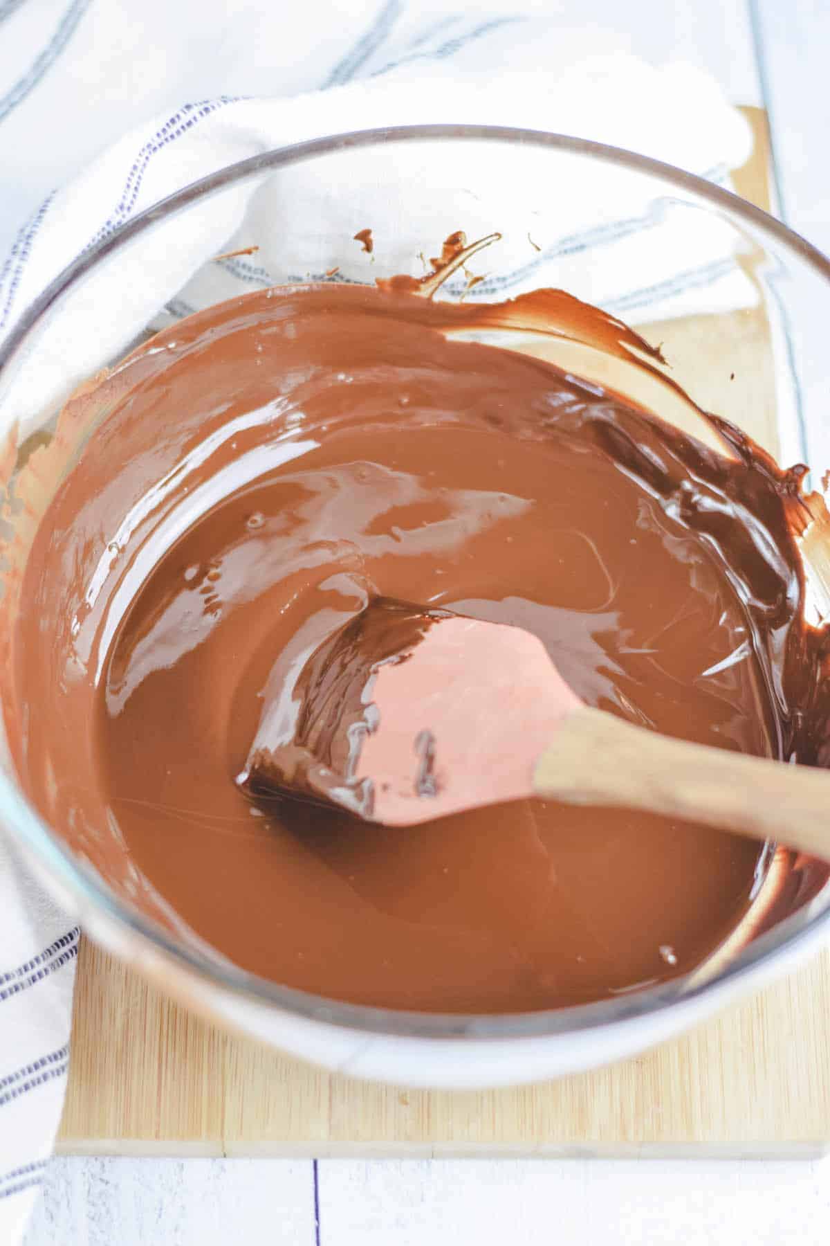 melting the dark chocolate bars in the glass bowl with a spatula