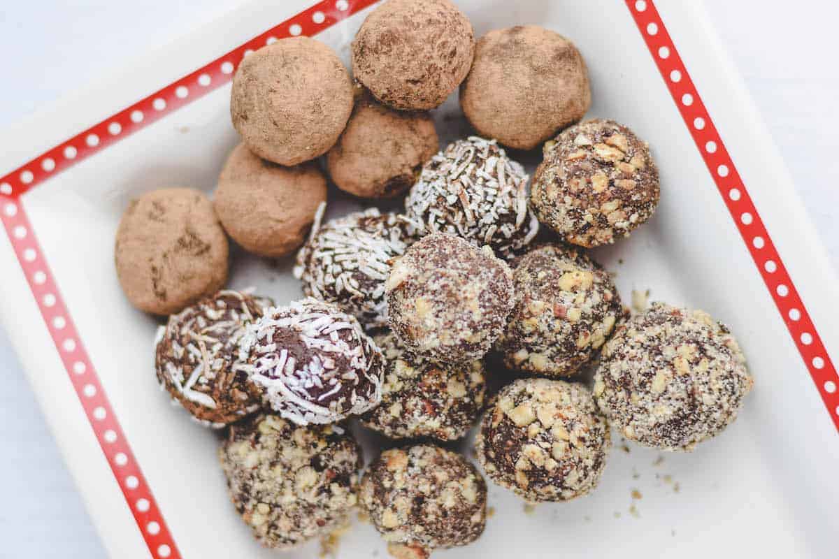 stack of dark chocolate truffles on a white platter