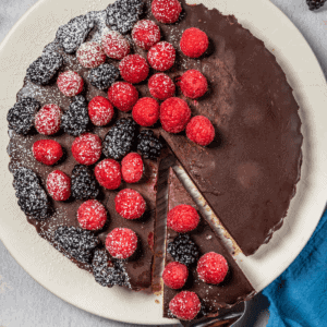 chocolate raspberry tart with a slice on a serving utensil