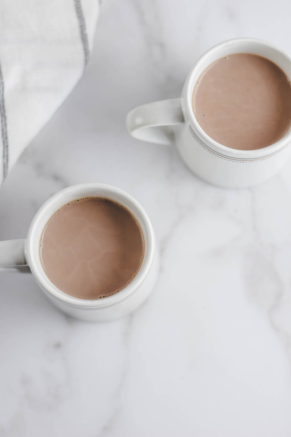 two white mugs with the warmed up mocha mixture