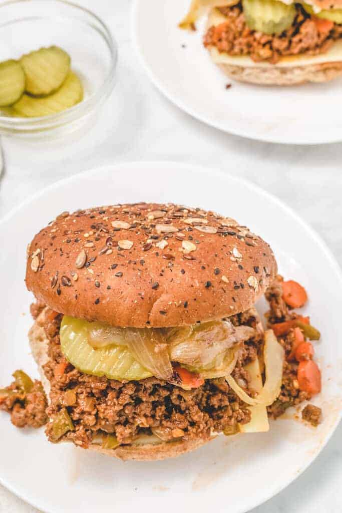 white plates of healthy sloppy joes and pickles in a small pinch bowl