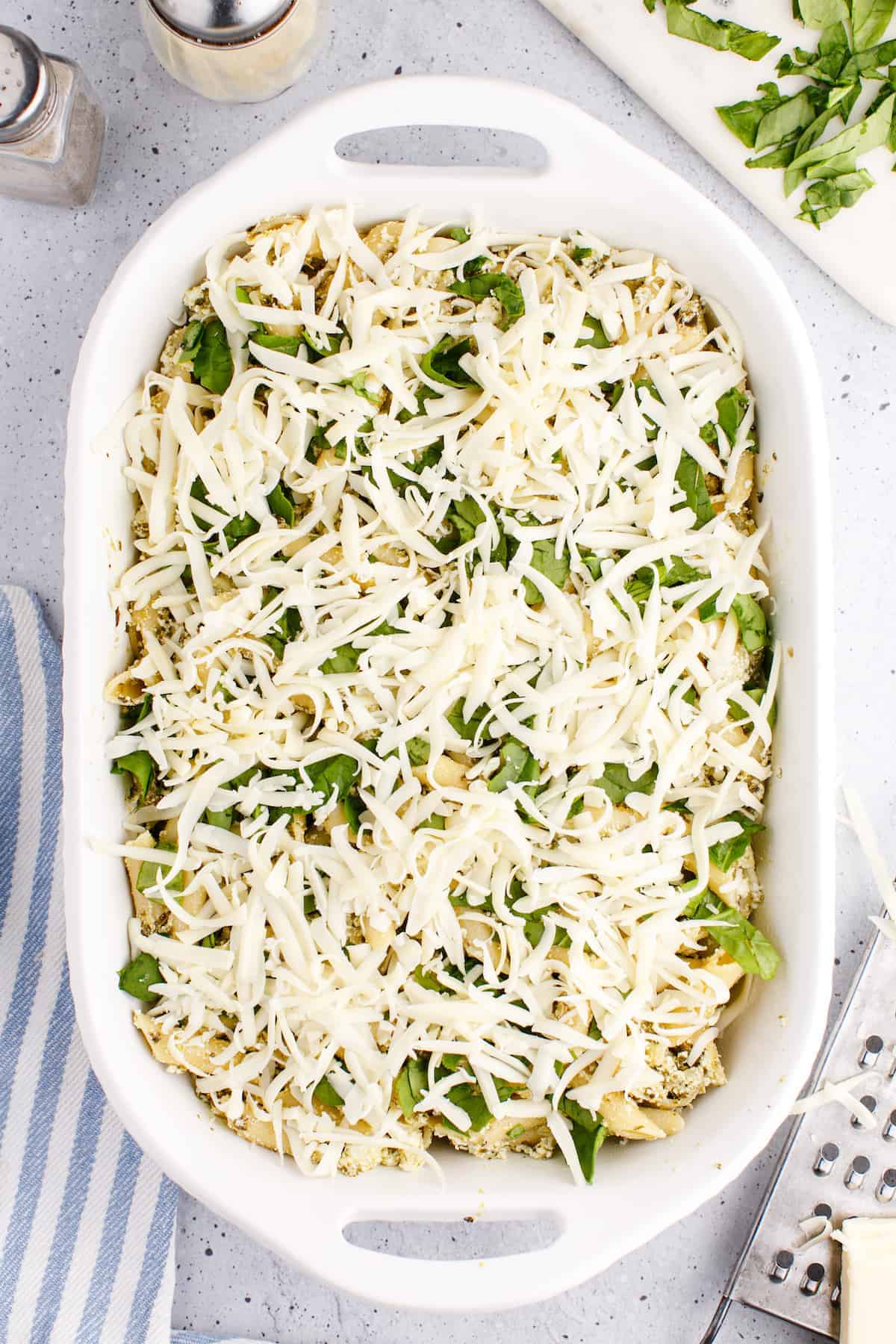the pasta and spinach is topped with shredded mozzarella cheese