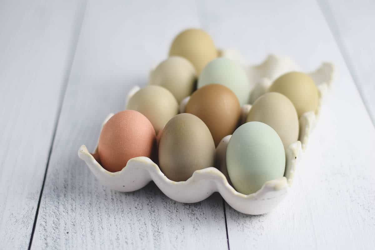 ceramic egg basket with colorful chicken eggs 