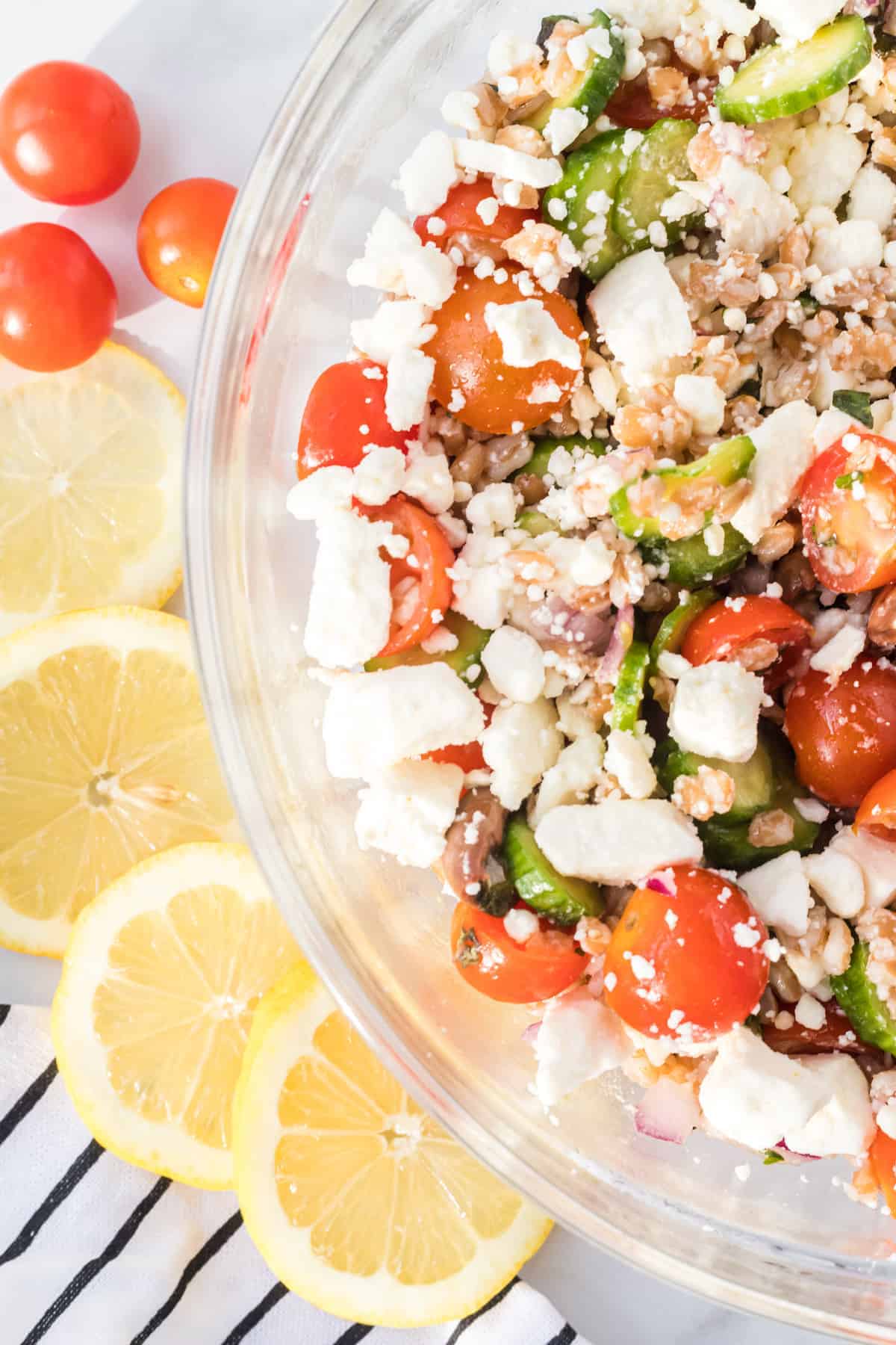 close up of the farro salad with slices of lemon and cherry tomatoes to the side