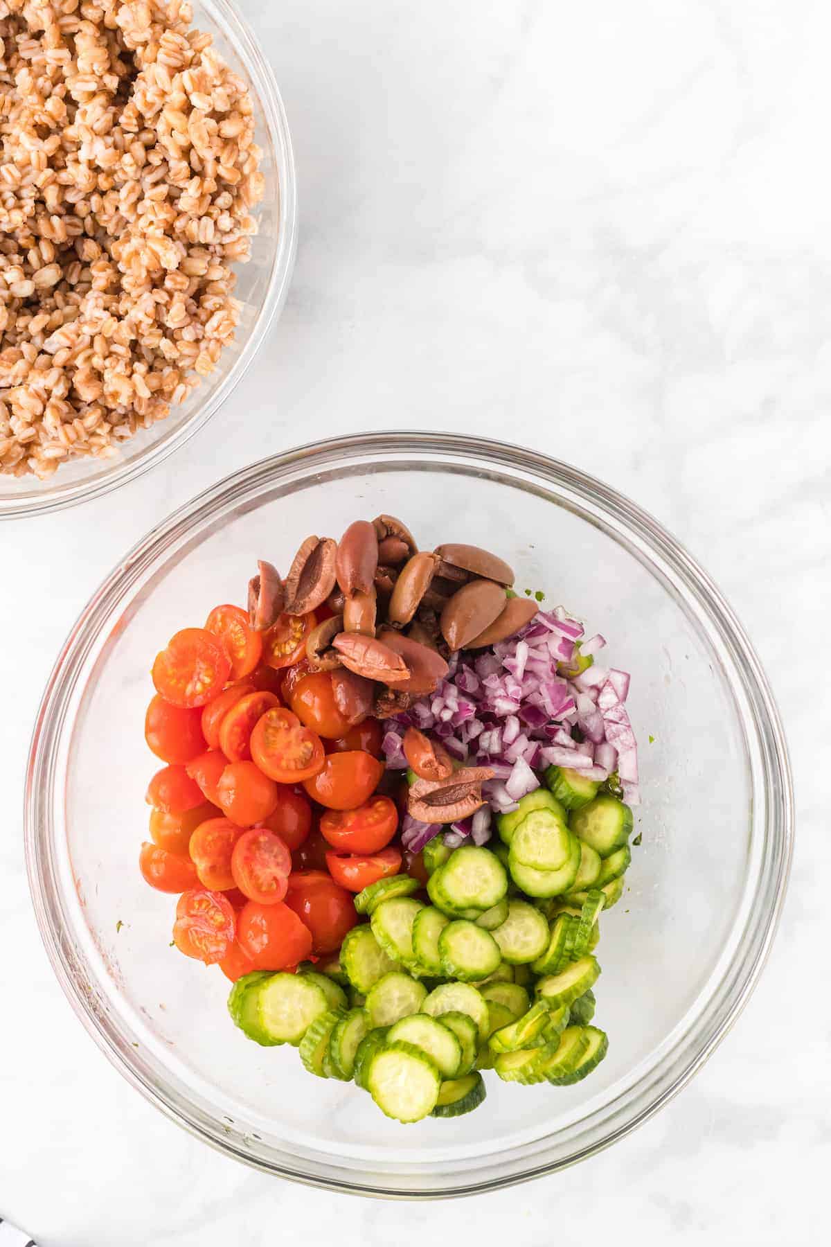 tomatoes, onions, cucumbers, olives in a bowl.