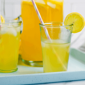 two glasses of healthy lemonade with white and light pink paper straws.