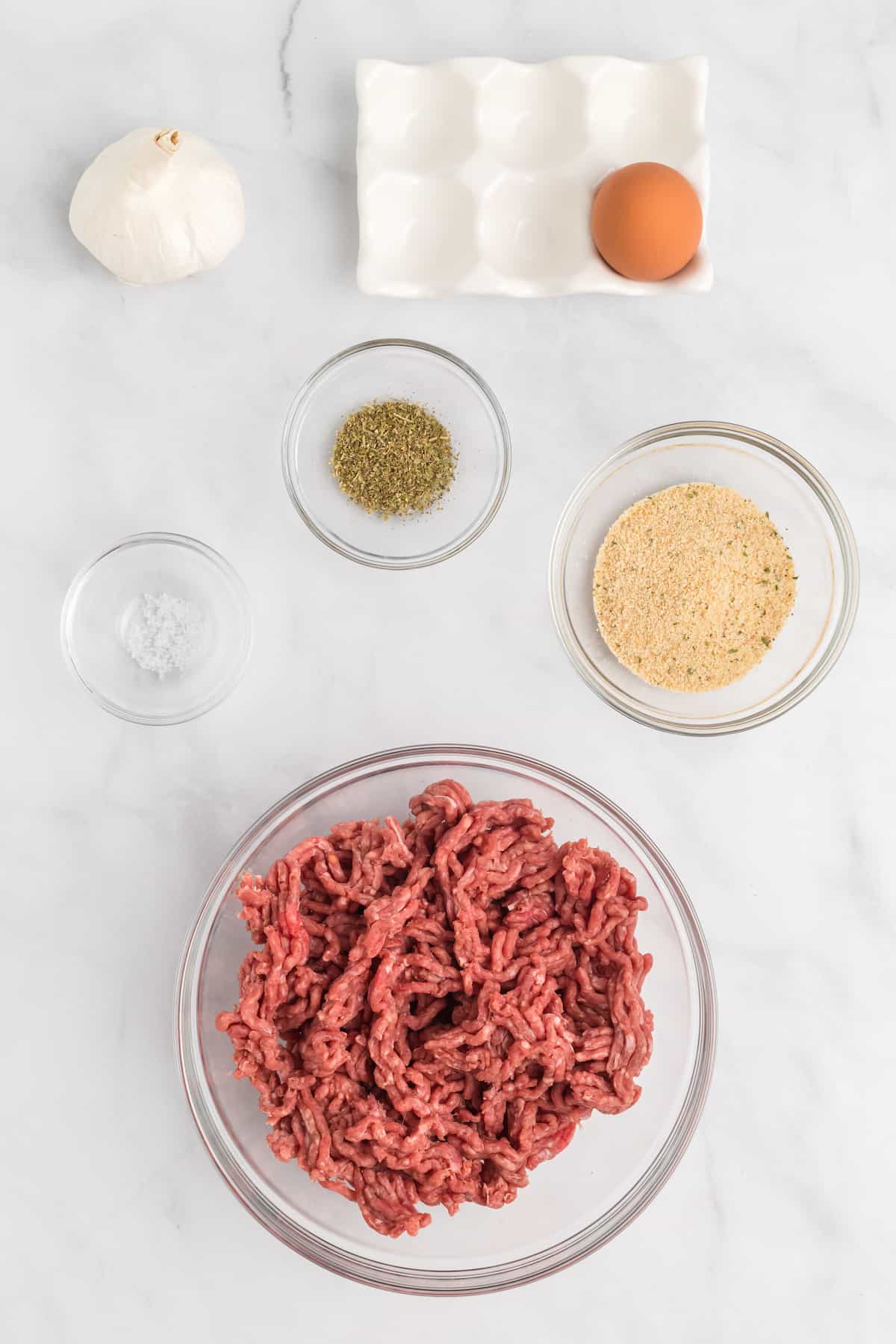 ingredients for the meatballs in small glass bowls.