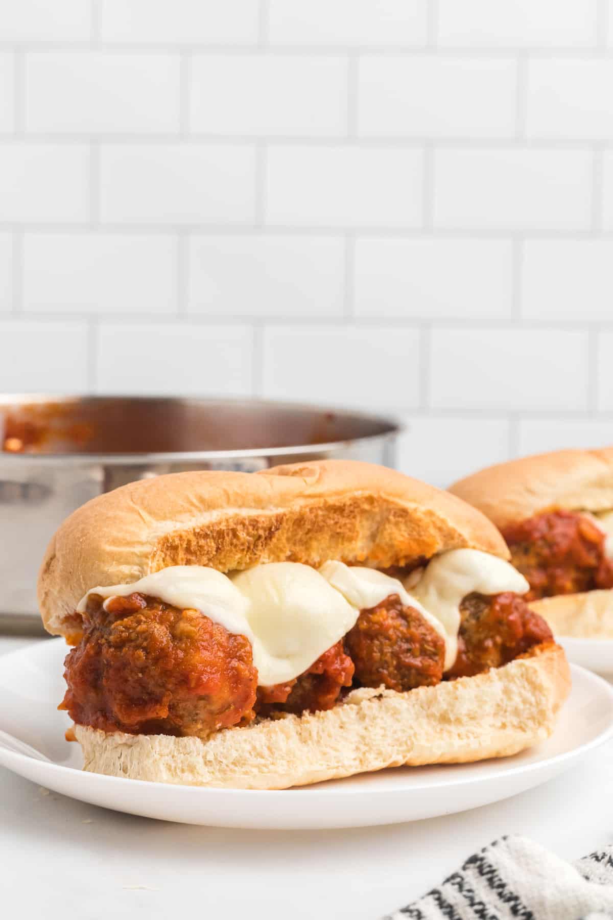 melted mozzarella cheese on top of the meatball subs.