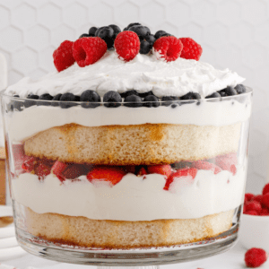 berry trifle layered between whipped cream and cake
