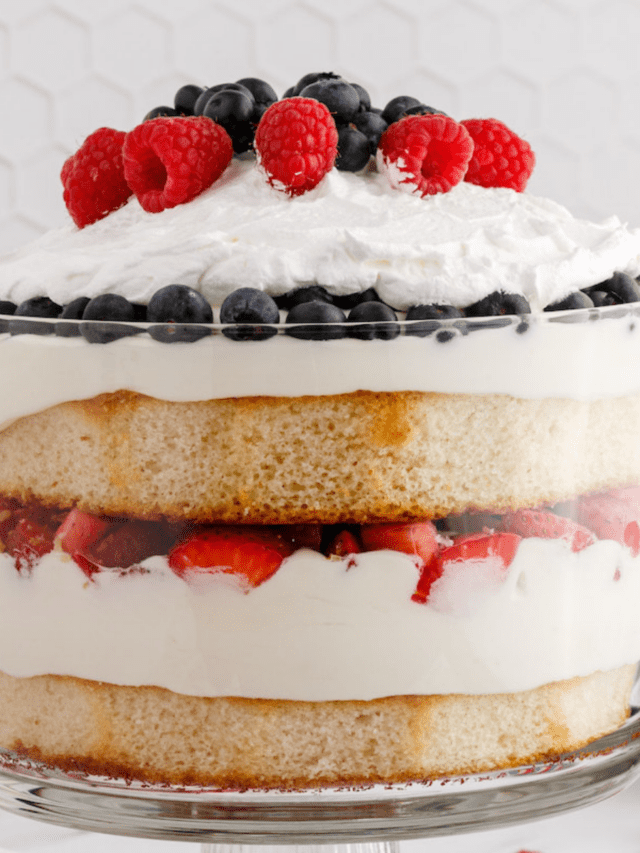 berry trifle layered between whipped cream and cake