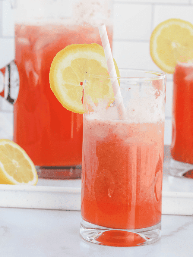 glass pitcher with two large glasses of strawberry lemonade.