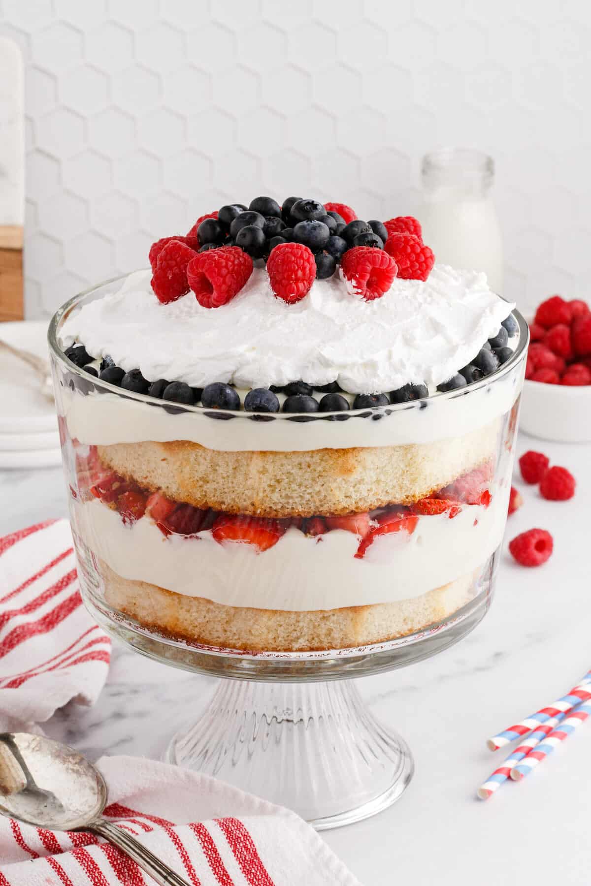 summer berries layered with pudding and whipped cream between layers of cake