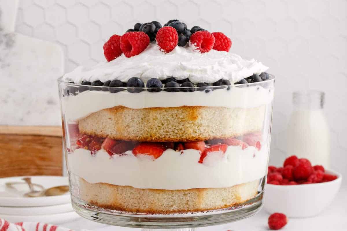 trifle dish layered with cake and fresh berries.