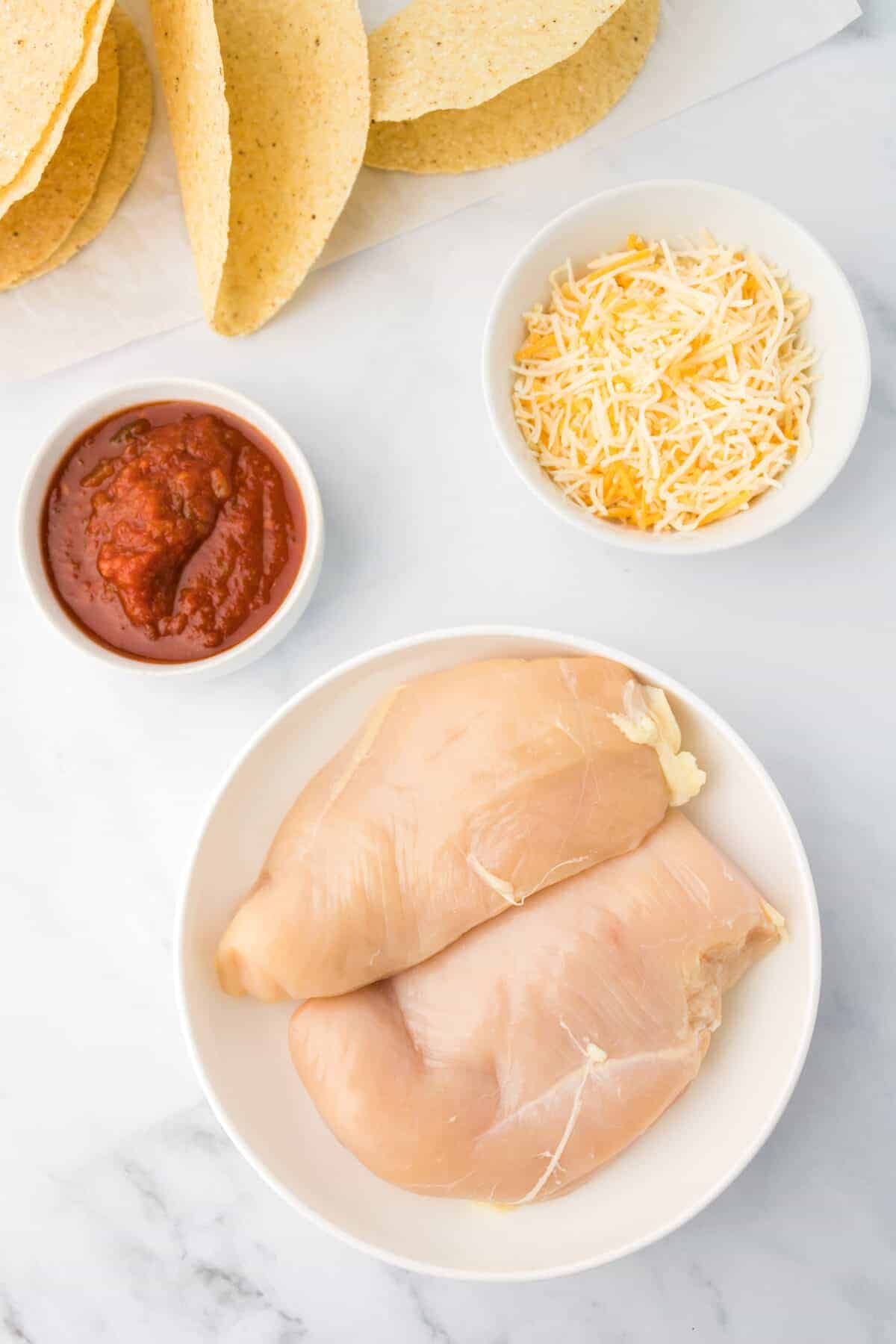 instant pot chicken tacos ingredients in small bowls and plates. 