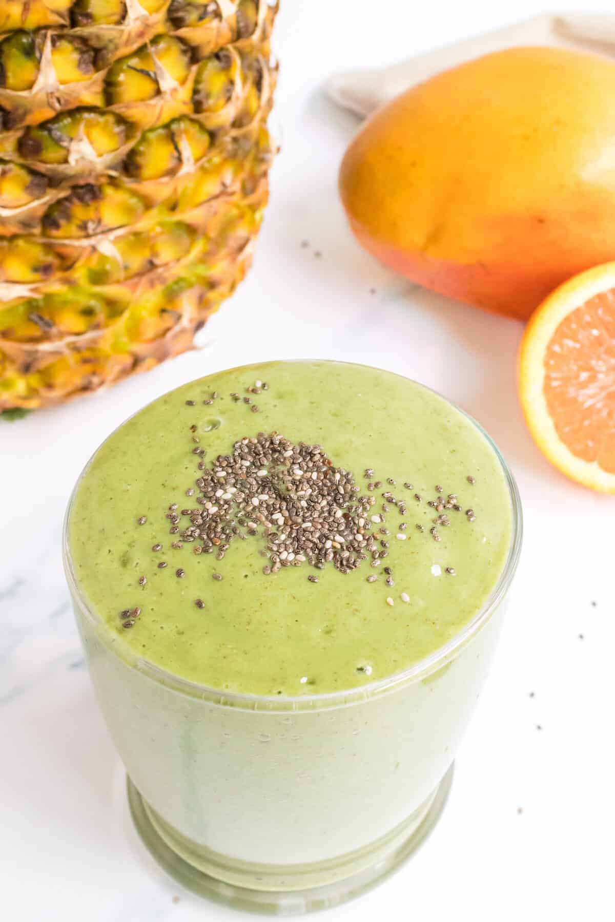 chia seeds on top of the tropical green smoothie in a glass.