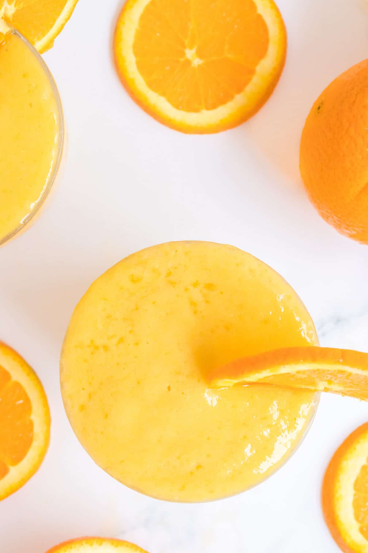 top down view of the glasses of orange mango smoothie.