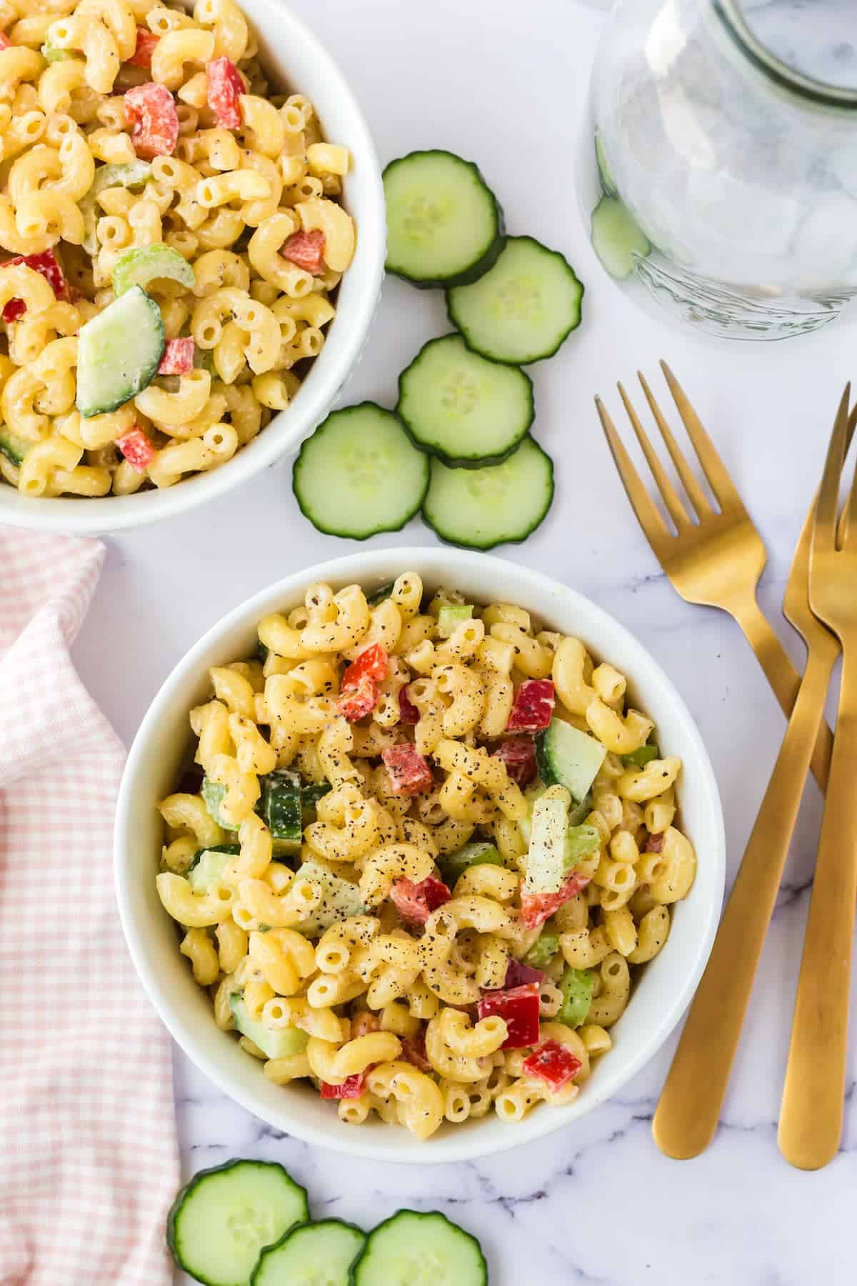 two white bowls with macaroni salad.