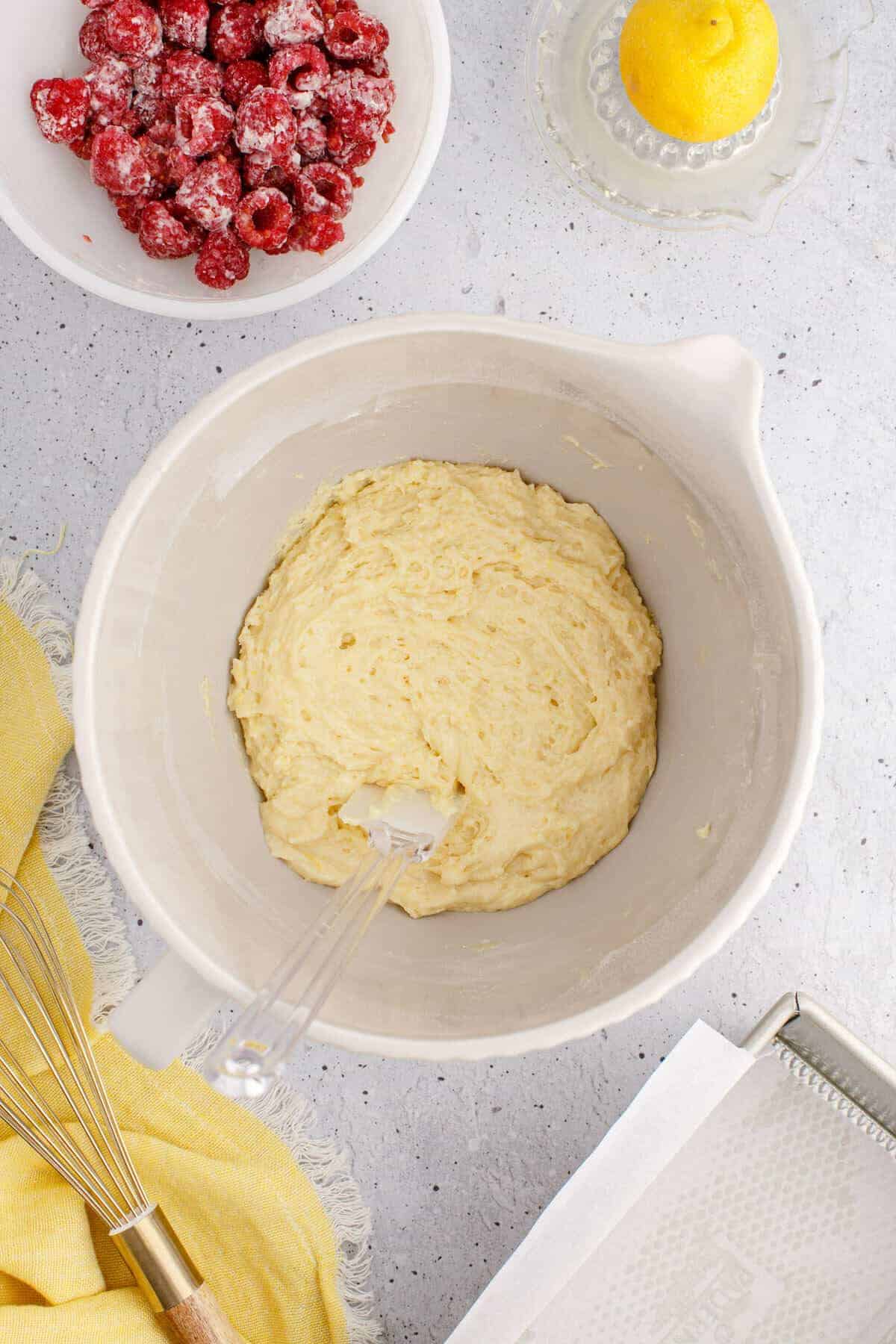 combined dry and wet ingredients in a mixer bowl with a white spatula inside.