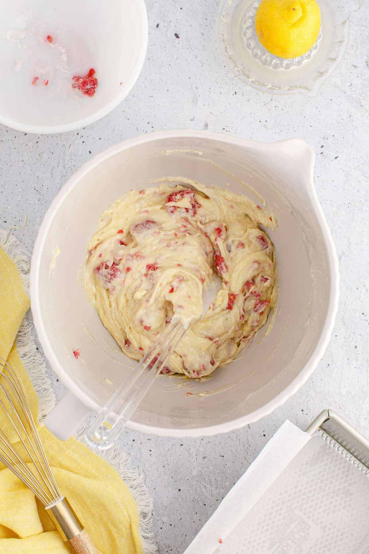 cake bread in a mixing bowl with the raspberries folded in.