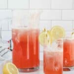 strawberry lemonade in glasses and large glass pitcher.