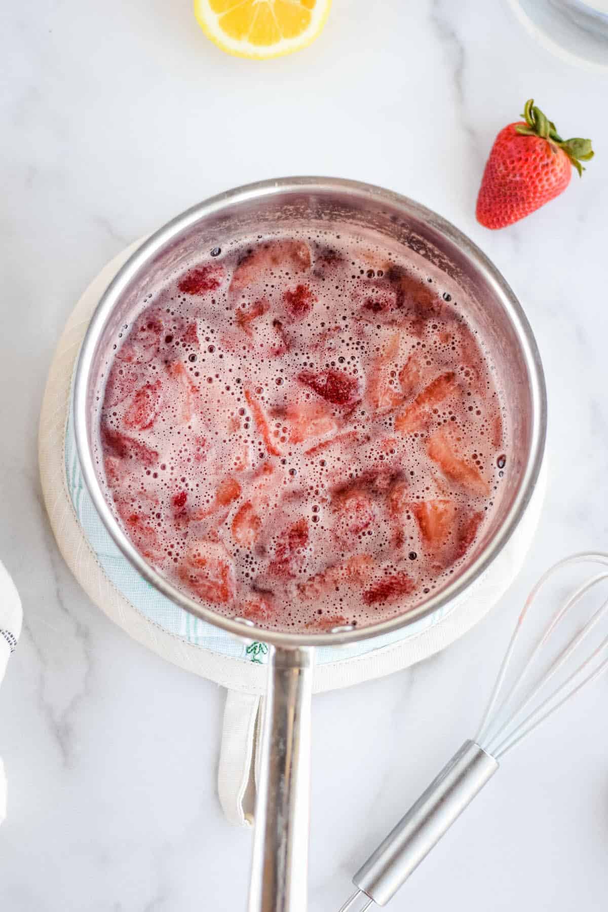 sauce pan of strawberry and honey syrup mixture.