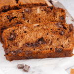 slices of banana bread with chocolate chunk pieces on parchment paper.
